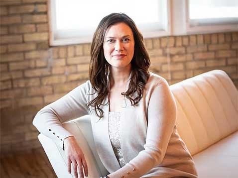 Smiling woman sitting on a small sofa